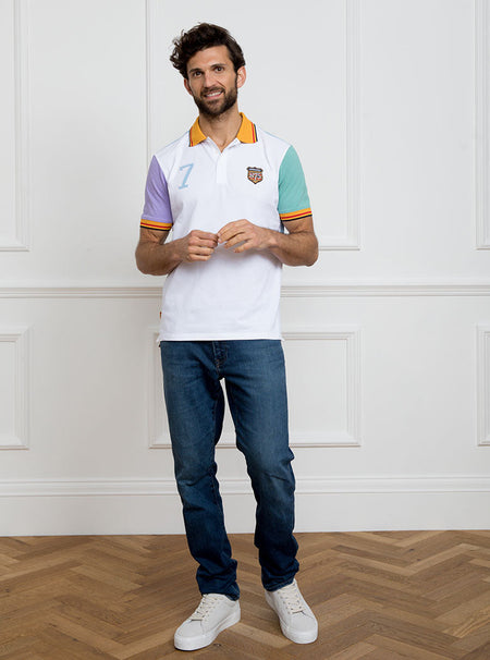 Man wearing multicoloured polo shirt with newmarket 875 crest on the front and number 7 on the back, made of 100% cotton.
